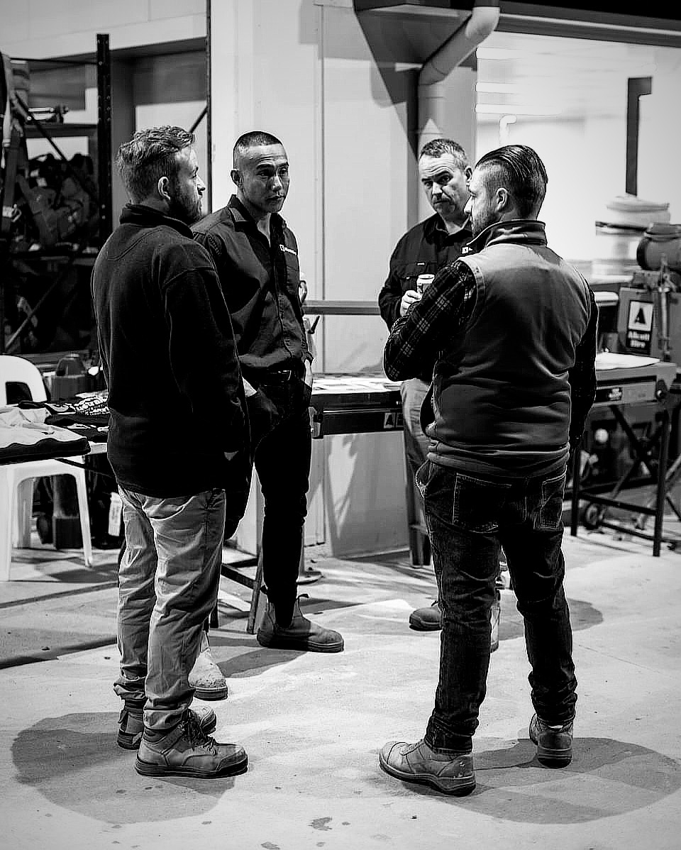 Aaron in conversation with a small group of men at an industry event