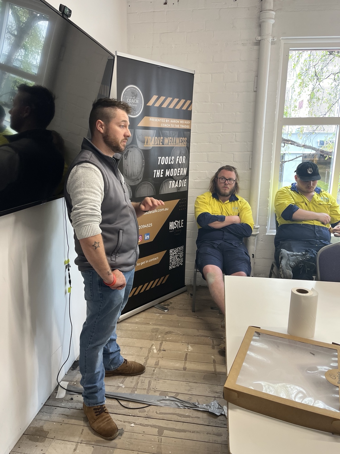 Aaron leading a small group workshop with workers seated around a table